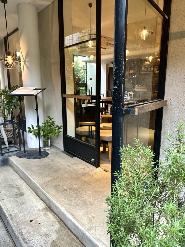 カフェの入口付近の緑豊かな空間。木の温もりとハーブの香りで心身がリラックスできる雰囲気。